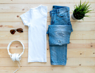 flat lay White tshirt mockup short jeans headphones and Sunglasses on brown wooden background. Template,