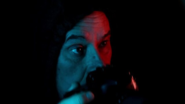 middle-aged man in dark in black hood secretly photographs close-up, concept paparazzi, peeps, illegally tracks down personal secrets of neighbors, concept of industrial espionage, surveillance