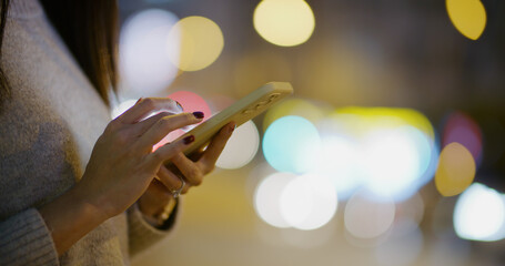 Woman use of mobile phone in street at night