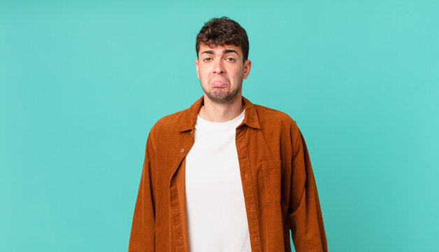 handsome man feeling sad and whiney with an unhappy look, crying with a negative and frustrated attitude