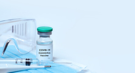 Vial of coronavirus vaccine,medical mask, protective glasses, syringe,thermometer on a white background.The concept of medicine, healthcare, science.Copy space for text