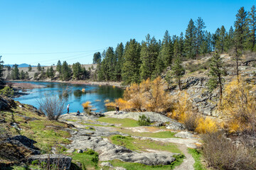 Visitors enjoy an early Spring day at Falls Park, along the Spokane River and Dam in Post Falls, Idaho USA	