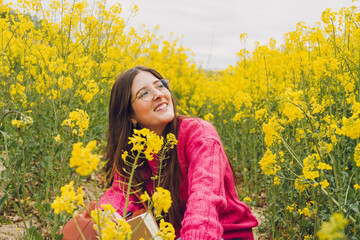 Woman in a field of yellow flowers enjoying nature