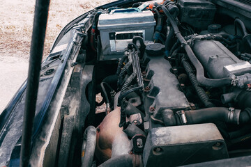 Open hood of the car. View of the engine and vehicle parts. Diagnostics and repair of old car.