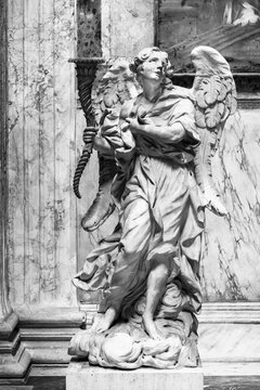 Black and white photo of decorative angel statue inside church in Rome