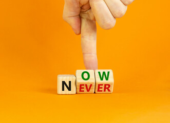 Now or never symbol. Businessman turns wooden cubes and changes the word 'never' to 'now' or vice versa. Beautiful orange background, copy space. Business and now or never concept.