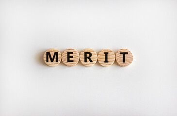 Merit symbol. Wooden circles with the word 'merit'. Beautiful white background, copy space....