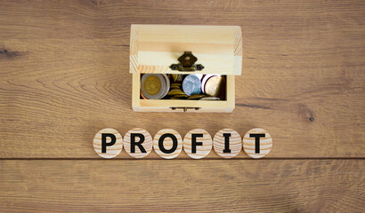 Profit symbol. Concept word profit on wooden cubes on a beautiful wooden background, small wooden chest with coins. Business and profit concept.