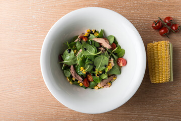 Tuna Salad in white bowl on wooden table