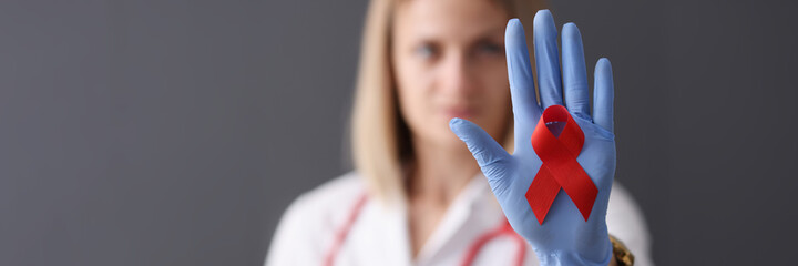 Doctor holds red ribbon in his hand.