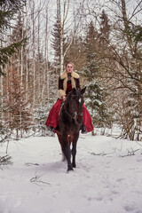 A girl in a beautiful old-fashioned burgundy dress on a horse .
