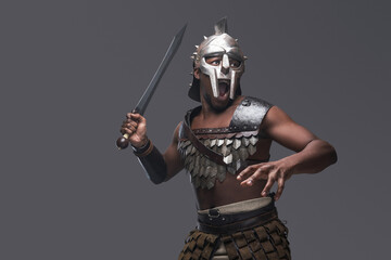 Violent gladiator with sword against gray background