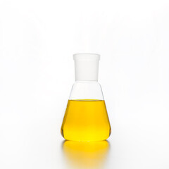 Chemistry flask with transparent yellow liquid for science research and experiment. Close up.