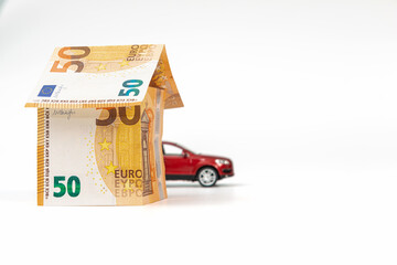 House from euro banknotes and car, isolated. loan, real estate and car insurance concept