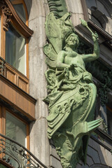Fototapeta na wymiar Sculpture on the facade of a historic building Singer House on Nevsky Prospect of St. Petersburg