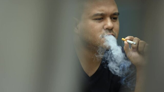 Young men smoking He smoked and spat out a lot of smoke. It is dangerous to the people around. World No Tobacco Day.