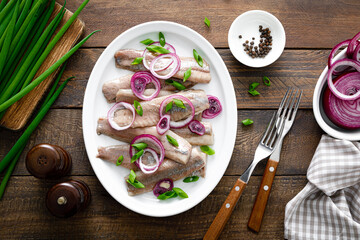 Pickled herring fillet with onion on plate