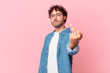 hispanic handsome man feeling angry, annoyed, rebellious and aggressive, flipping the middle...