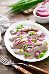 Pickled herring fillet with onion on plate