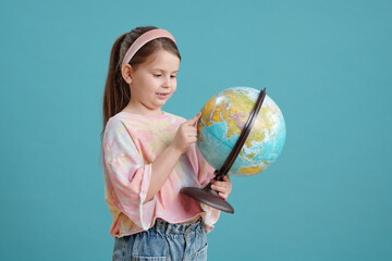 Little girl examining globe