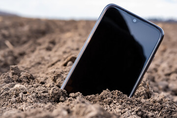 the phone sticks out of the ground in the field