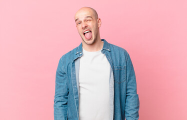 bald man with cheerful, carefree, rebellious attitude, joking and sticking tongue out, having fun