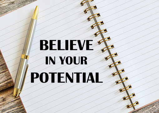 Top view of a pen with Believe In Your Potential written on a notebook.