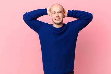 bald man feeling stressed, worried, anxious or scared, with hands on head, panicking at mistake