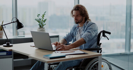 Disabled invalid young male designer working in corporate office, developing creative ideas and...