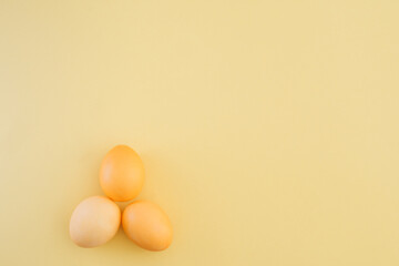 Minimalistic Easter composition with yellow Easter eggs on a yellow background. Copy space, top...