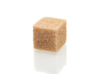 Brown cube of cane sugar isolated on white background. Close up view.