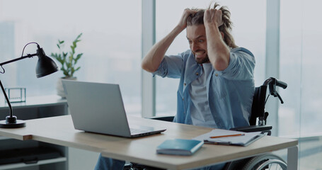 Depressed angry young man office worker losing computer data having problem internet connection screaming inside office corporate space. Emotions. Disabled person.