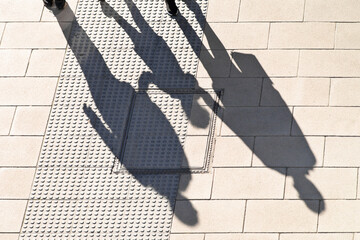 shadow of couple with child  walking holding hands in street city