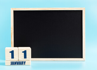 January 11. Day 11 of month, Cube calendar with date, empty frame on light blue background. Place for your text. Winter month, day of the year concept