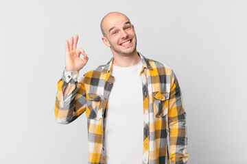 bald man feeling happy, relaxed and satisfied, showing approval with okay gesture, smiling
