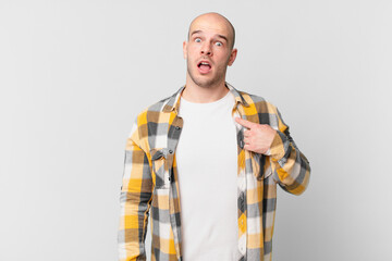 bald man looking shocked and surprised with mouth wide open, pointing to self