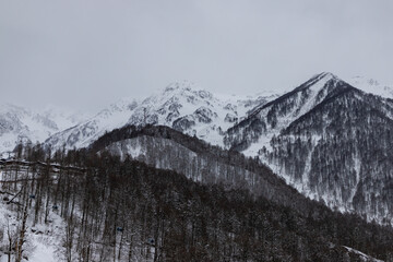 Obraz premium View of the mountain range at cloudy day from the Olympic Village in Krasnaya Polyana, Sochi