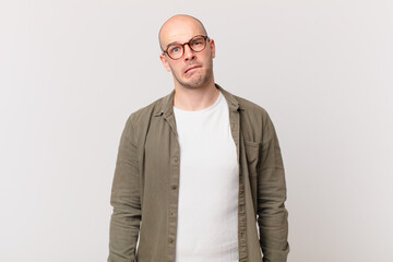 bald man looking puzzled and confused, biting lip with a nervous gesture, not knowing the answer to...