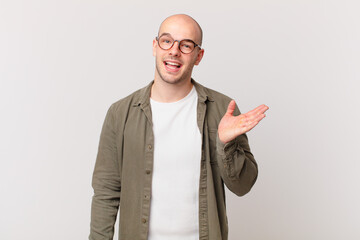 bald man feeling happy, surprised and cheerful, smiling with positive attitude, realizing a...