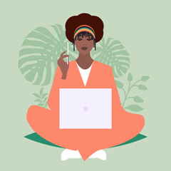 African business woman sitting comfortably with a laptop and a pencil, surrounded by plants
