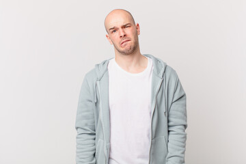bald man looking puzzled and confused, biting lip with a nervous gesture, not knowing the answer to...