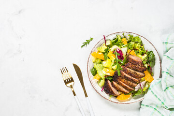 Salad with baked duck, green salad mix and oranges.