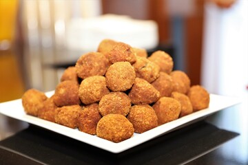 Close up of freshly cooked bonda on a big plate with other snacks on the background