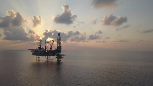 Aerial view of the jack up rig shot during sunset time. Fly around the jack up rig with a drone.
