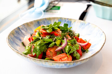 Salad of fresh tomatoes and cucumbers is on the plate