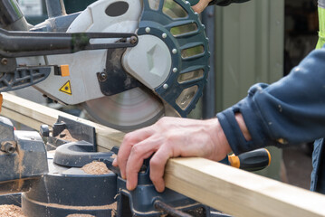 Carpenter using circular saw in DIY project.