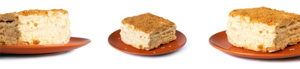A square piece of Napoleon cake on an orange round plate. Close-up. Side view. macro