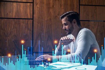 A serious caucasian analyst in casual wears, using laptop to proceed the forecast of behavioral statistic information. Double exposure. Graph Hologram. Concept of analytics in consulting.