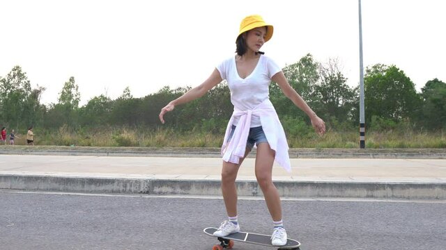 Hipster beautiful asian girl play surfskate on the road,Activities of modern adolescents,New hobbies during COVID-19
