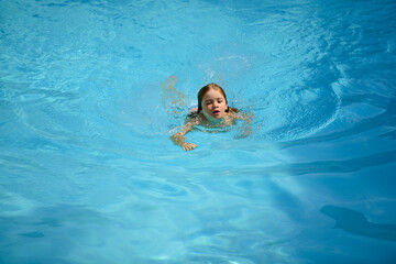 Child swimming in pool. Kids summer. Summertime attractions. Swimmingpool.